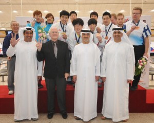 Doubles medalists on the podium with medal presenters and team officials